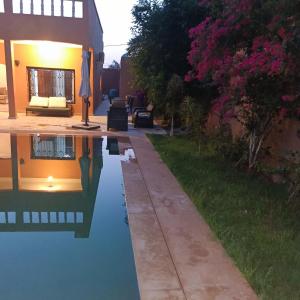 a house with a pool of water in a yard at Villa Ama in Marrakech
