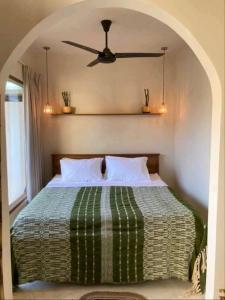 ein Schlafzimmer mit einem Bett mit Deckenventilator in der Unterkunft Seseh Hacienda in Munggu