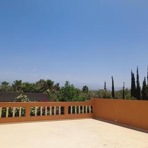 a balcony with a wooden fence with trees in the background at Villa Ama in Marrakesh