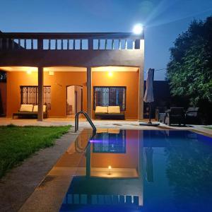 a swimming pool in front of a house at night at Villa Ama in Marrakech