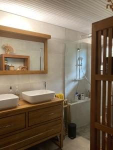 a bathroom with a sink and a mirror and a tub at Maison camomille in Le Cap