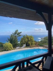 a swimming pool with a view of the ocean at Maison camomille in Le Cap