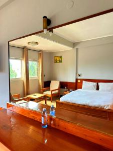 1 dormitorio con 1 cama grande y espejo grande en Royal Village Hotel, en Dar es Salaam