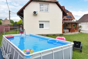 a little girl standing in front of a swimming pool at Sonia Vendégház in Bogács