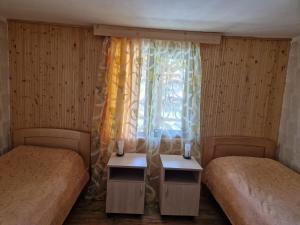 una camera con due letti e una finestra con tende di Guesthouse Mevele a Omalo