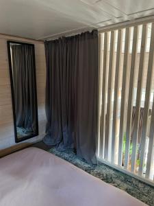 un porche cubierto con una ventana con cortinas en Kalana Kapteni Beach House en Kalana