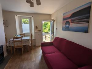 a living room with a red couch and a table at ﻿Ca Lola in St Bees