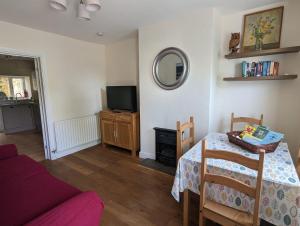 a living room with a table and a tv at ﻿Ca Lola in St Bees