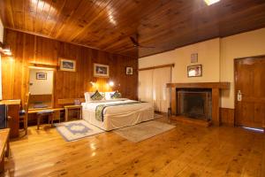 a bedroom with a bed and a fireplace at Hotel Negi's Mayflower A heritage Since 1965 in Manāli