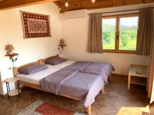 ein Schlafzimmer mit einem Bett und einem großen Fenster in der Unterkunft Accommodation "MONTELAGO"- Virpazar,Skadar Lake in Virpazar