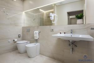 a bathroom with a toilet and a sink at Rivazzurra Beach Rooms in San Vito lo Capo