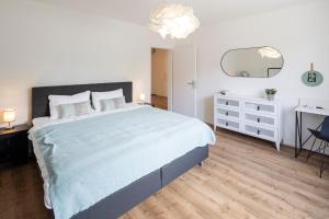 1 dormitorio con 1 cama grande, vestidor y espejo en STAYY Bijou Balgrist nahe Spital - gratis Parkplatz en Zúrich