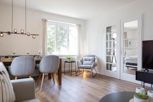 a living room with a dining room table and chairs at STAYY Bijou Balgrist nahe Spital - gratis Parkplatz in Zürich