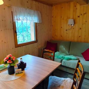 a living room with a wooden table and a couch at Koča Velika Planina - Chalet Kamrica in Stahovica