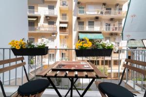 uma mesa e duas cadeiras numa varanda com flores em Lyto by Heloni Apartments em Atenas