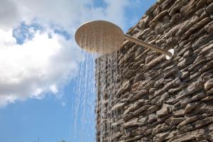 una ducha en la parte lateral de un edificio en Villa Theolia, en Gouvia
