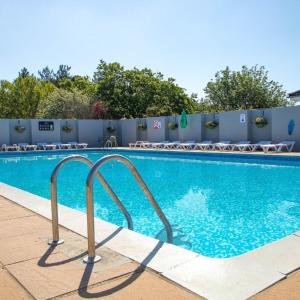 a swimming pool at a hotel with chairs around it at Westerley Cove in Lymington