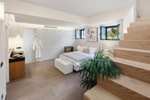 a bedroom with a white bed and a staircase at Villa Theolia in Gouvia