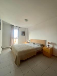 Un dormitorio con una cama grande y una ventana en Apartment-Duplex, El Medano, en El Médano