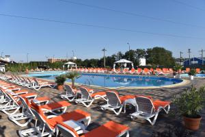 a row of lounge chairs next to a swimming pool at Madrigal Boutique Rooms in Scheia