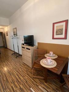 a living room with a table and a television at Prague Old Town Apartment Benediktska 6 in Prague