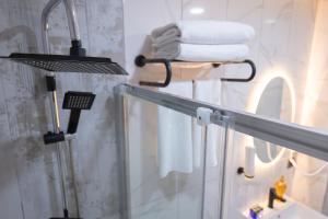 a bathroom with a shower and a sink with towels at Galata Greenland Hotel in Istanbul