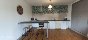 una cucina con bancone e sgabelli di Maison clarette a Carhaix-Plouguer