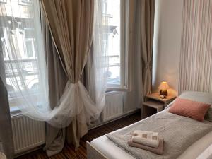a bedroom with a bed and a large window at Prague Old Town Apartment Benediktska 6 in Prague