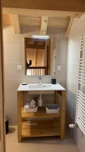 a bathroom with a sink and a mirror at Chalet La Mahure in La Toussuire