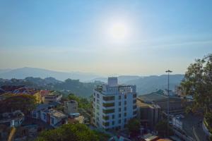 uma vista para uma cidade com montanhas ao fundo em Emerald Hotel em Āīzawl