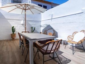 a table and chairs with an umbrella on a patio at REf 68 CASA MARGARITA in Zahara de los Atunes