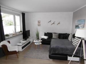 a living room with a black couch and a table at Ferienwohnung Wiesenblick nahe Region Celle und Hannover in Buchholz Aller