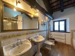 a bathroom with two sinks and a mirror and a toilet at Lis Fadis Wine Relais in Cividale del Friuli