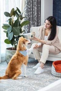 a woman sitting on a couch next to a dog at Abesq Doha Hotel and Residences in Doha