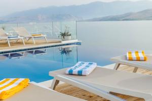 a swimming pool with two lounge chairs and a table at Hotel Plaza in Pag