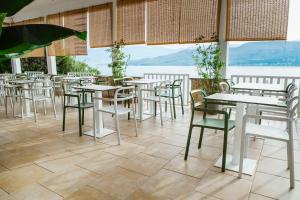 a restaurant with tables and chairs with a view at Hotel Plaza in Pag