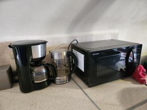 un forno a microonde e una macchinetta del caffè accanto a un tostapane di Jak Tu Sielsko a Osiek