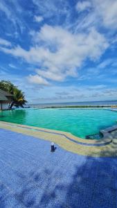 a swimming pool with turquoise water and palm trees at Water Scapes in Kumarakom