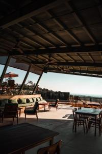 a patio with tables and chairs and a view of the ocean at Grün Resort Uluwatu in Uluwatu
