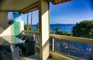 d'un balcon avec une table et des chaises donnant sur l'océan. dans l'établissement Ref MIDI - Palmes d'Or Properties, à Cannes