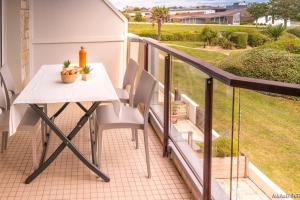 een tafel en stoelen op het balkon van een huis bij RÉF 323 LARMOR PLAGE 18 rue Beg Tal Men in Larmor-Plage