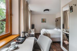 シュツァブニツァにあるHotel Batoryのベッド、デスク、鏡が備わる客室です。