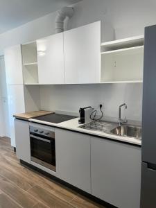 uma cozinha branca com um lavatório e um fogão em San Pellegrino Suites em San Pellegrino Terme
