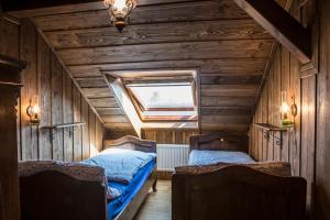 two beds in a room with wooden walls at Apartmány Loučný mlýn in Kněžmost