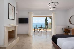 a bedroom with a bed and a fireplace and a television at Eretria Luxurious Seafront Villa in Chalkida