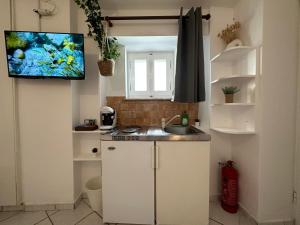 a kitchen with a sink and a tv on the wall at Valente Rooms Kythira in Kythira