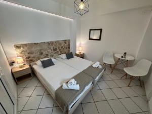 a bedroom with a large bed and two chairs at Valente Rooms Kythira in Kythira