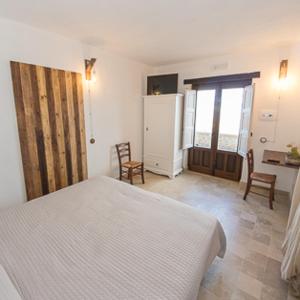 a bedroom with a bed and two chairs in it at Case al Borgo-Agira Centre-Home Relais in Agira