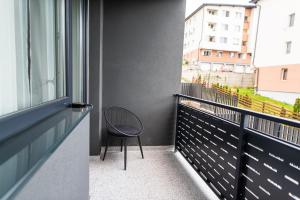 a chair sitting on a balcony with a window at TEILOR Apartments 1 in Floreşti