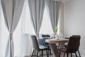 a dining room with a table and chairs in front of a window at TEILOR Apartments 1 in Floreşti